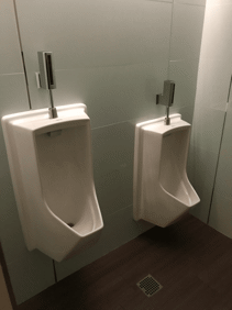 Two urinals in a bathroom, not five feet apart