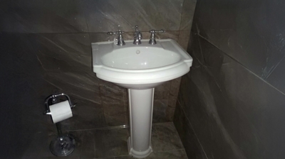 Installation of pedestal sink and faucet Photo